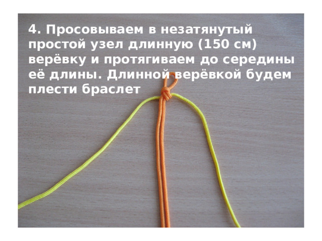 4. Просовываем в незатянутый простой узел длинную (150 см) верёвку и протягиваем до середины её длины. Длинной верёвкой будем плести браслет