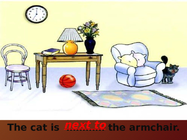 next to  The cat is ………… the armchair.
